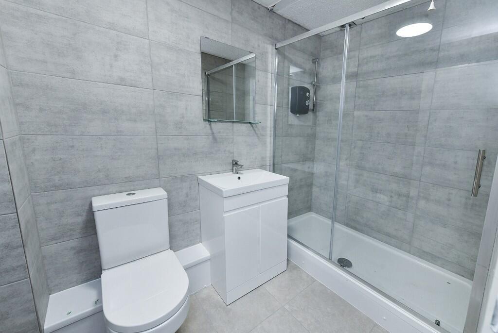Modern and clean bathroom featuring a toilet, a...