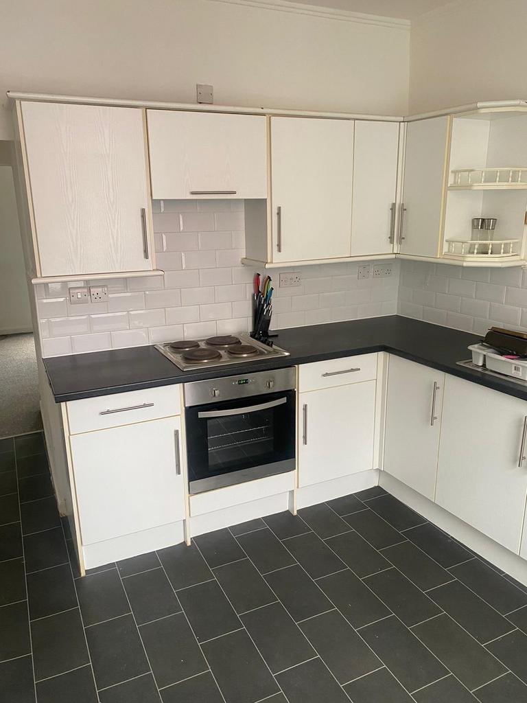 Bright and modern kitchen with white cabinetry,...