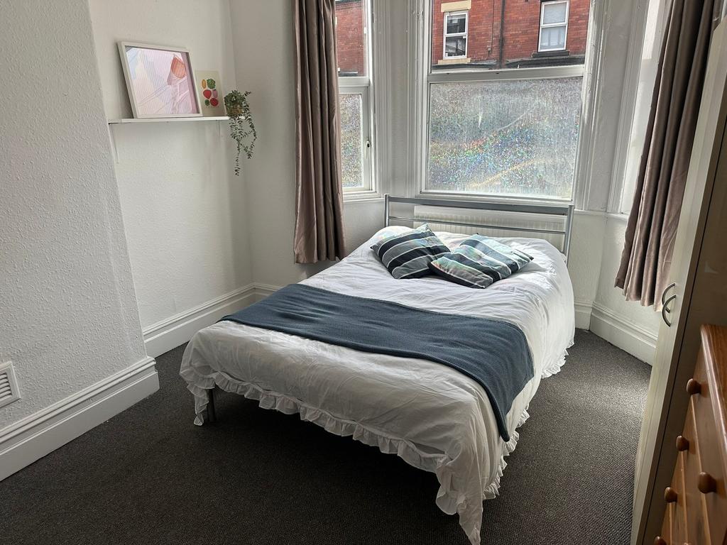 Bright and cozy bedroom with ample natural ligh...