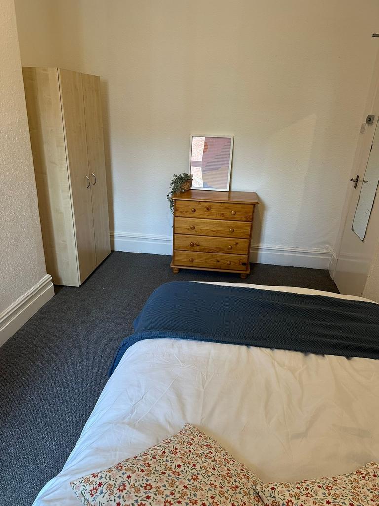 A cozy bedroom featuring a bed with a floral pi...