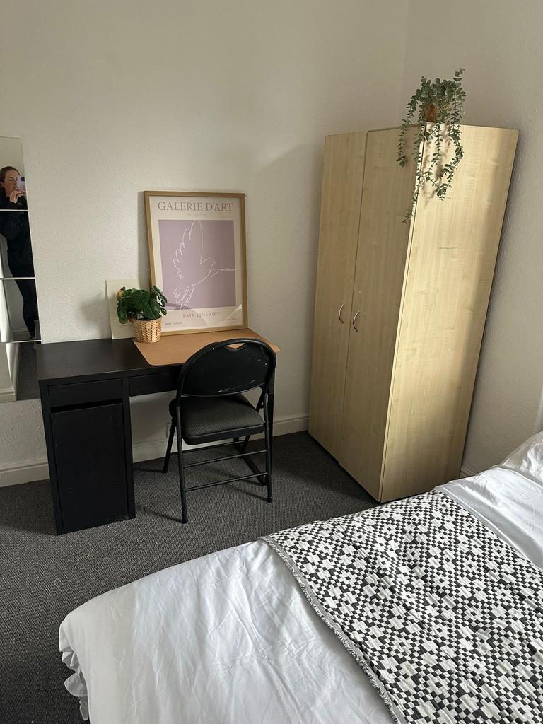 A cozy, well-maintained bedroom featuring a nea...