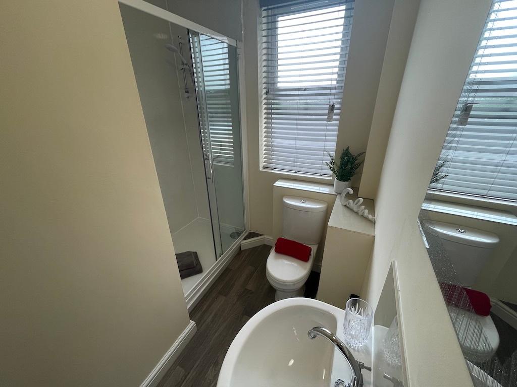 Bright, modern ensuite bathroom featuring a wal...