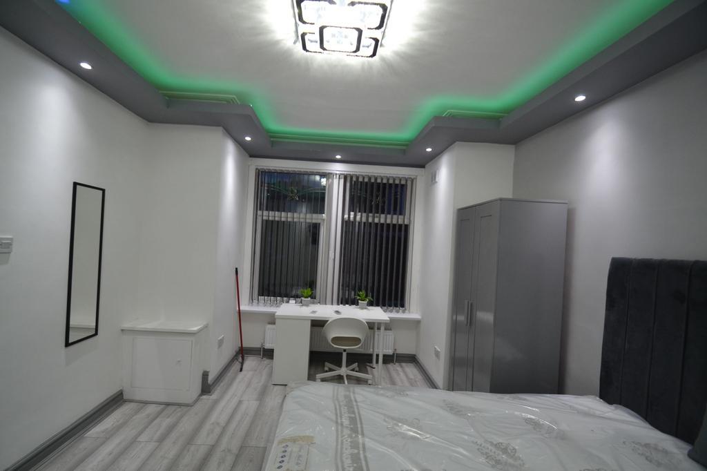 Bright, modern bedroom with stylish ceiling lig...