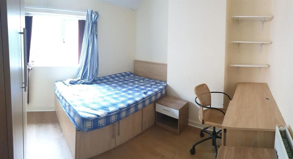 Bright single bedroom with a raised bed, built-...