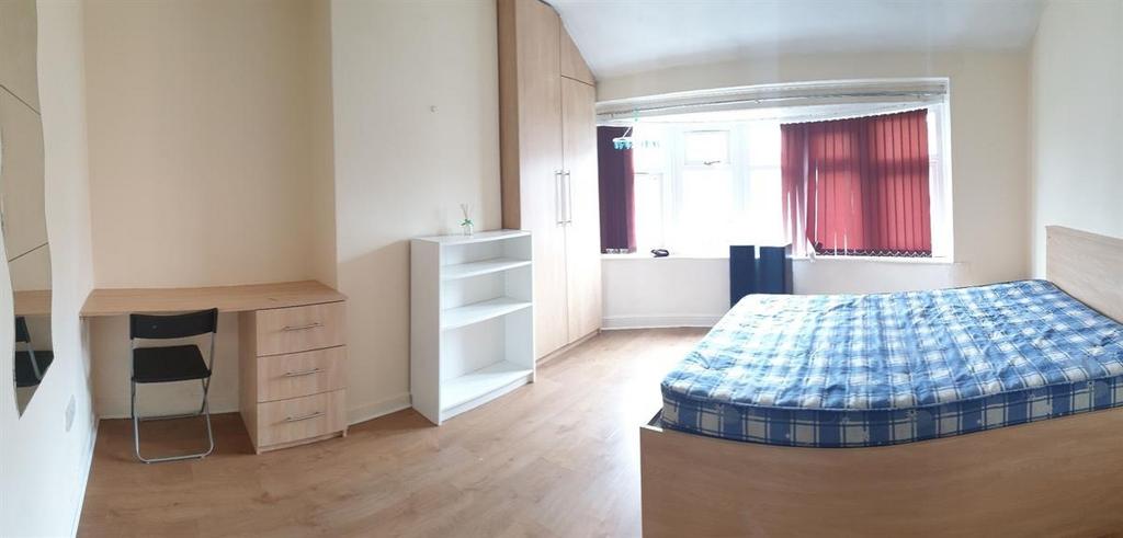 Bright, simply furnished bedroom with a double ...