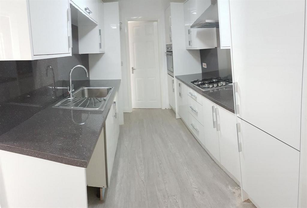 Bright, modern galley kitchen with sleek grey w...