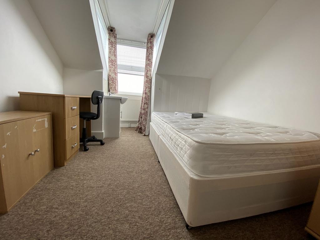 A cozy single bedroom featuring a comfortable b...