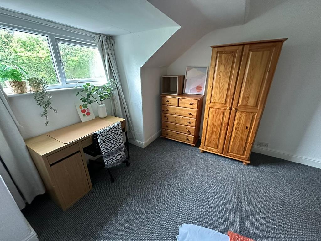 A cozy student bedroom featuring a window with ...