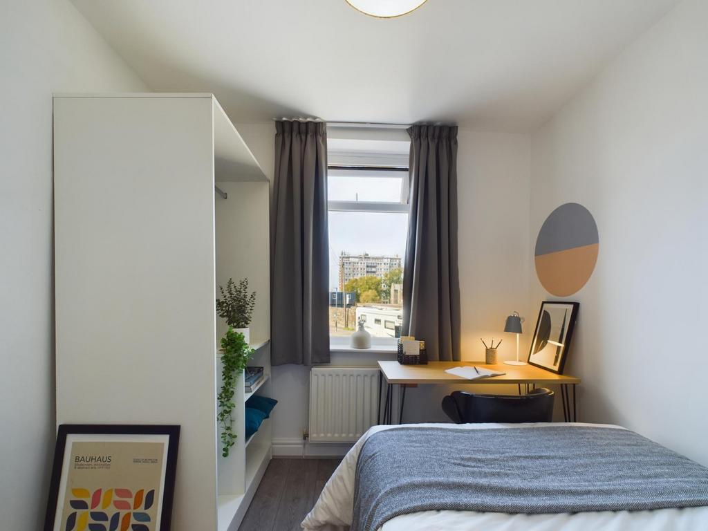 A bright and stylish double bedroom featuring a...