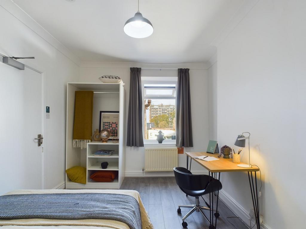 A bright and inviting double bedroom with a des...