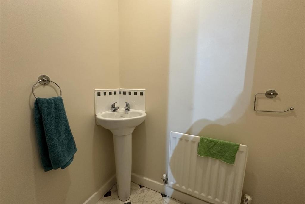 Compact corner washbasin in a neat cloakroom wi...