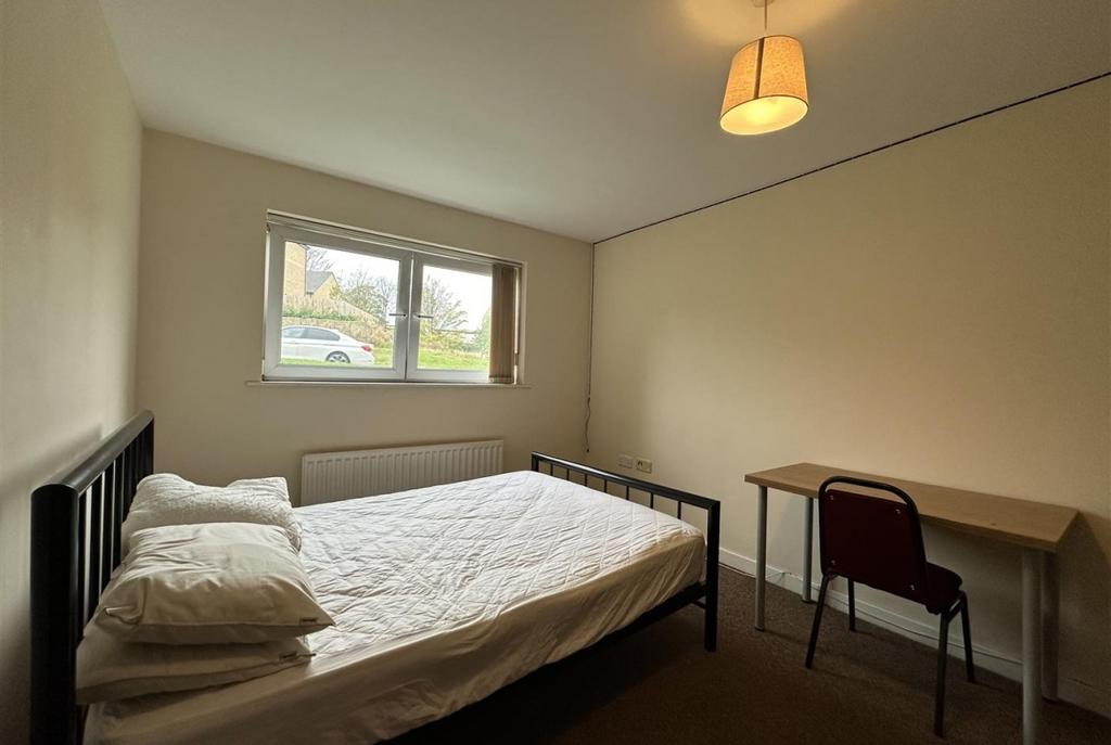 Bright, simply furnished bedroom with a double ...