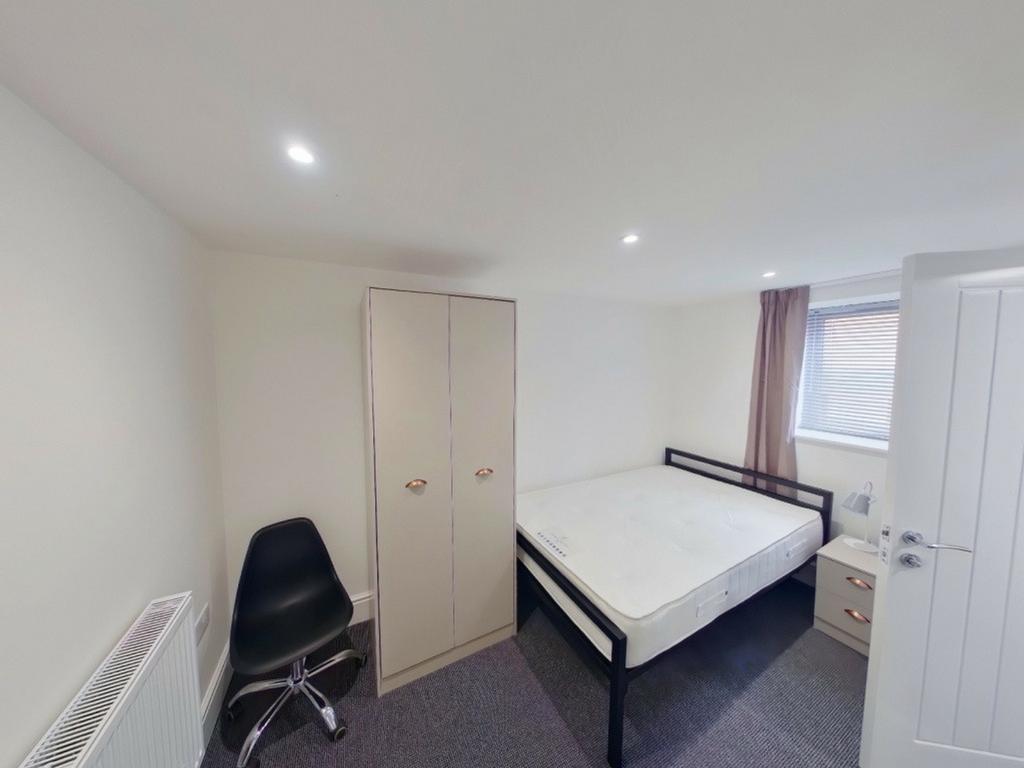 A spacious and bright double bedroom featuring ...