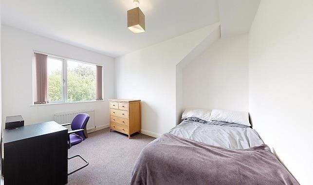 Bright, simply furnished bedroom with a double ...