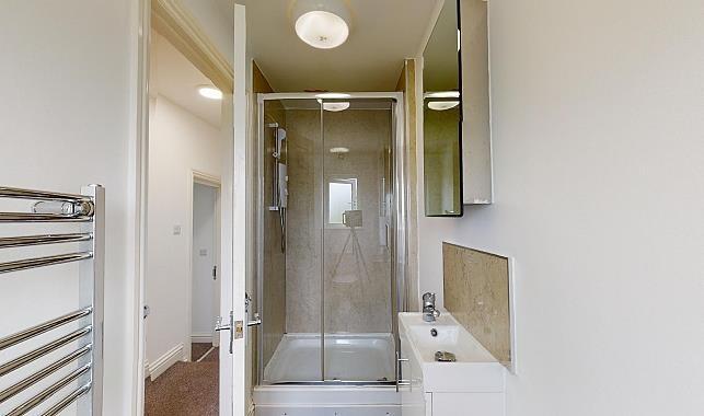Bright, modern bathroom with a glass-enclosed s...
