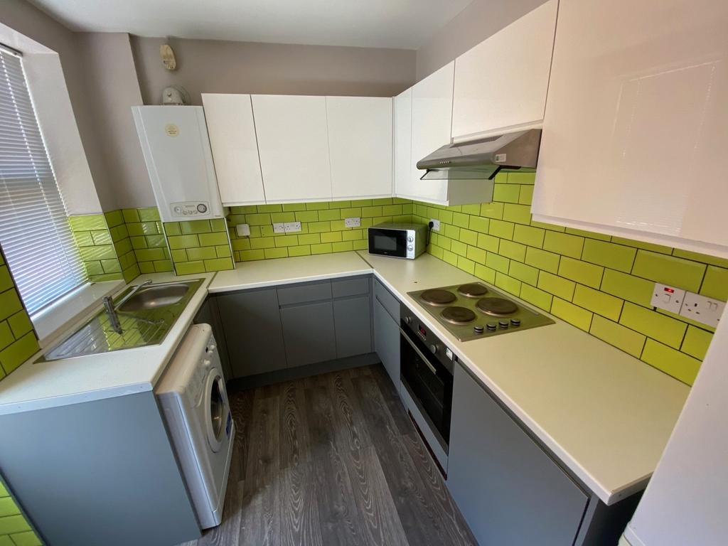 A bright and modern kitchenette with stylish gr...