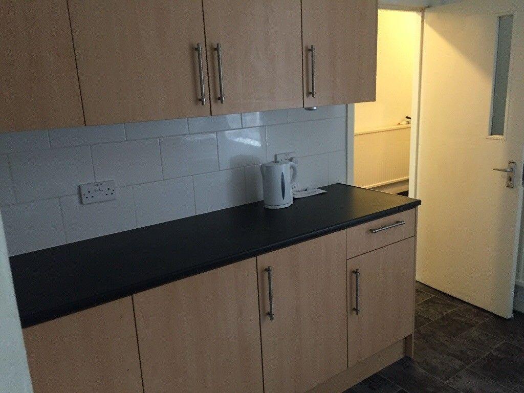 Neat galley-style kitchen with light wood cabin...