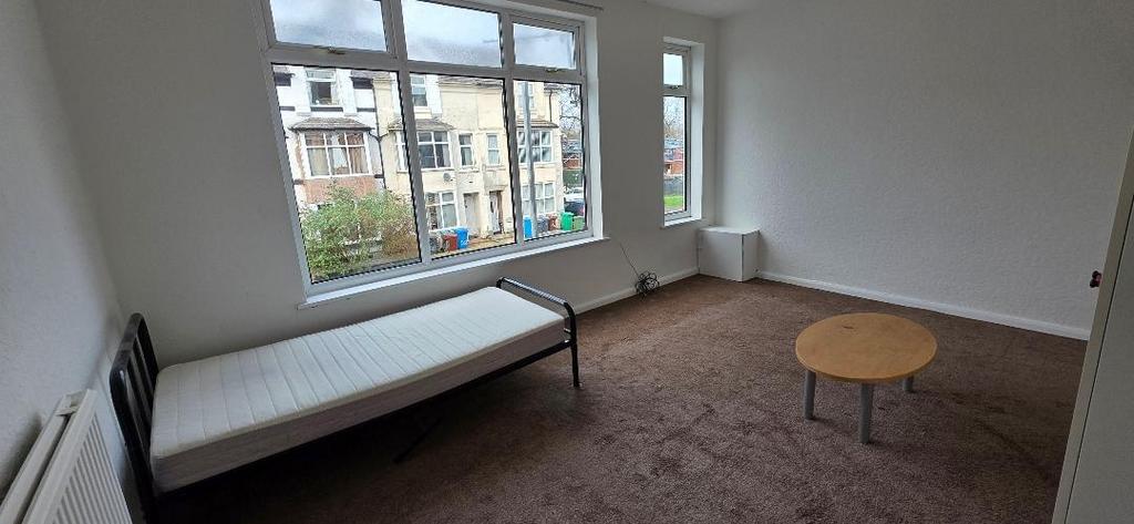 Bright room with large windows and simple fitti...