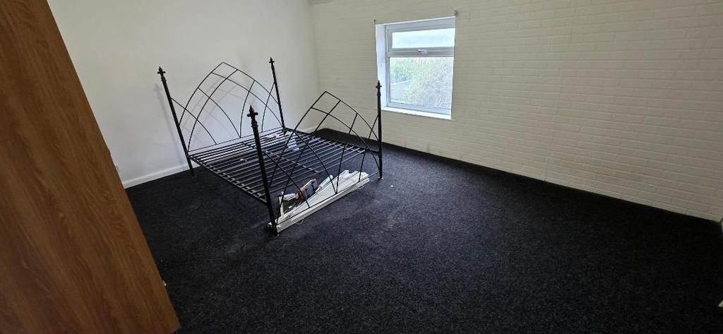 Spacious bedroom with large window and dark car...