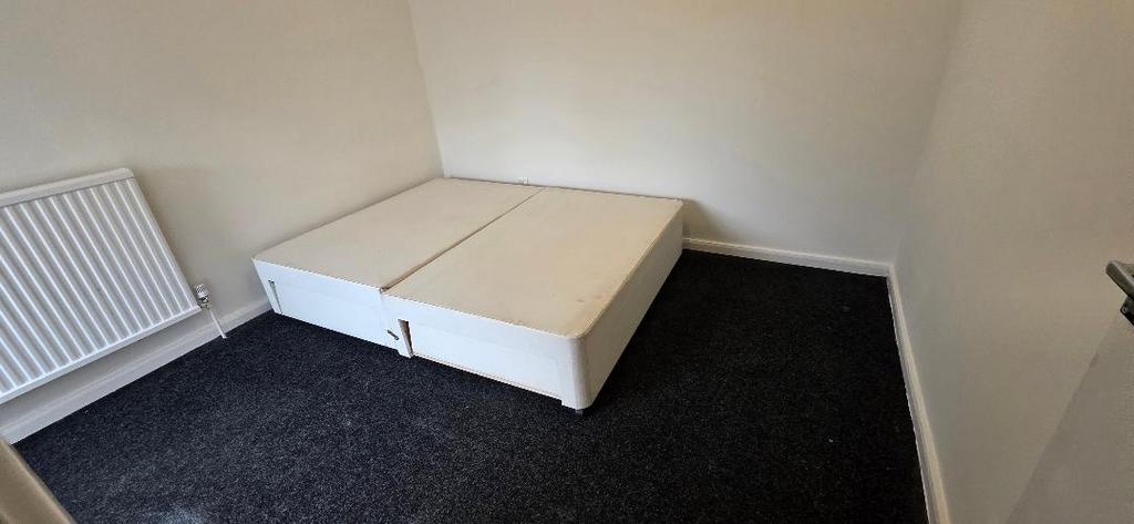 Compact room with clean decor and bed base...