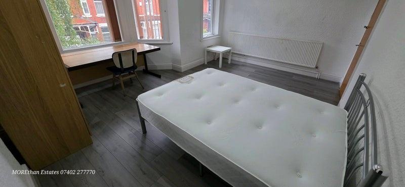 Bright double bedroom with large bay windows, a...