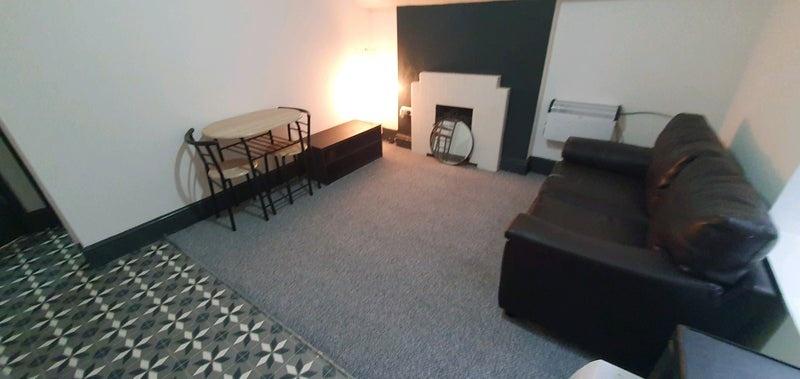 Cozy living room with a dark leather sofa, patt...