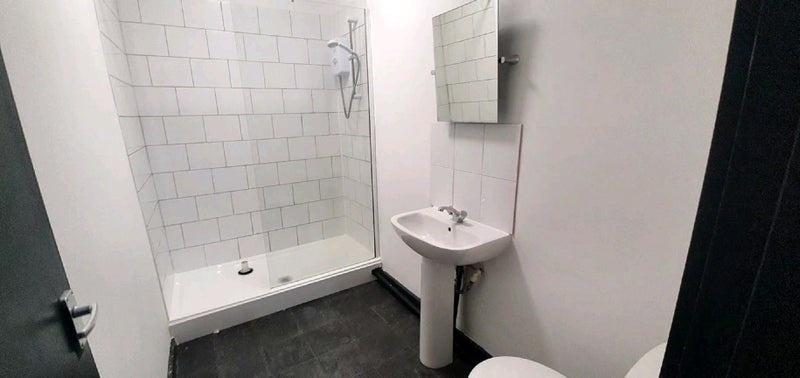 Clean modern bathroom with a tiled shower enclo...