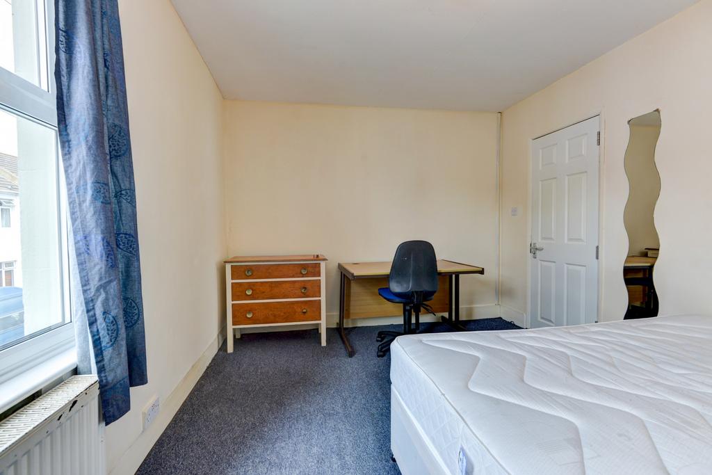 Bright, simply furnished bedroom with a double ...