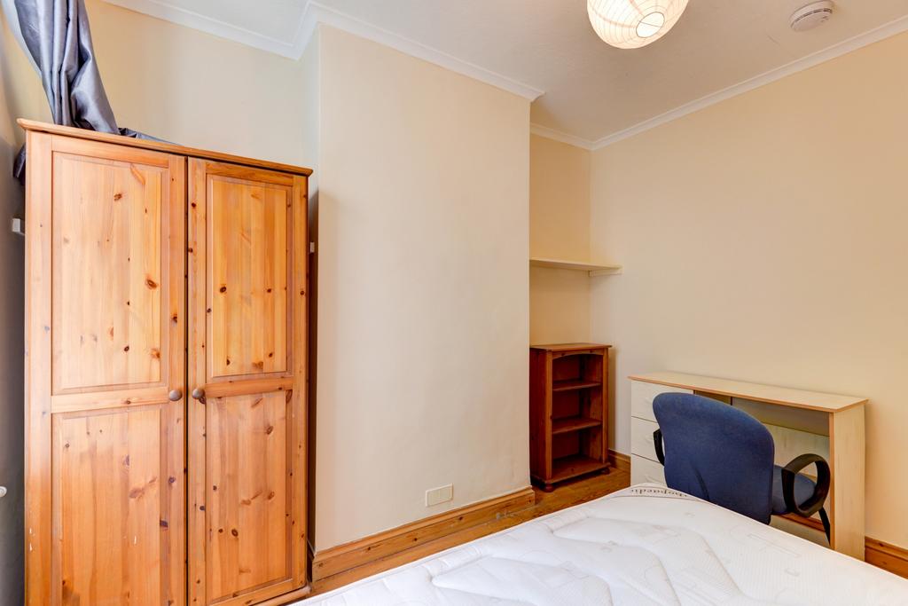 Bright, simply furnished bedroom with a double ...