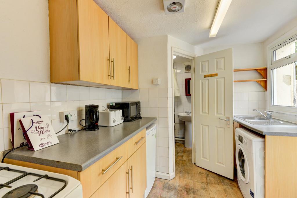 Bright galley-style kitchen with light wood cab...