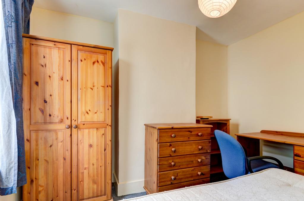 Neat furnished bedroom with a wooden wardrobe, ...