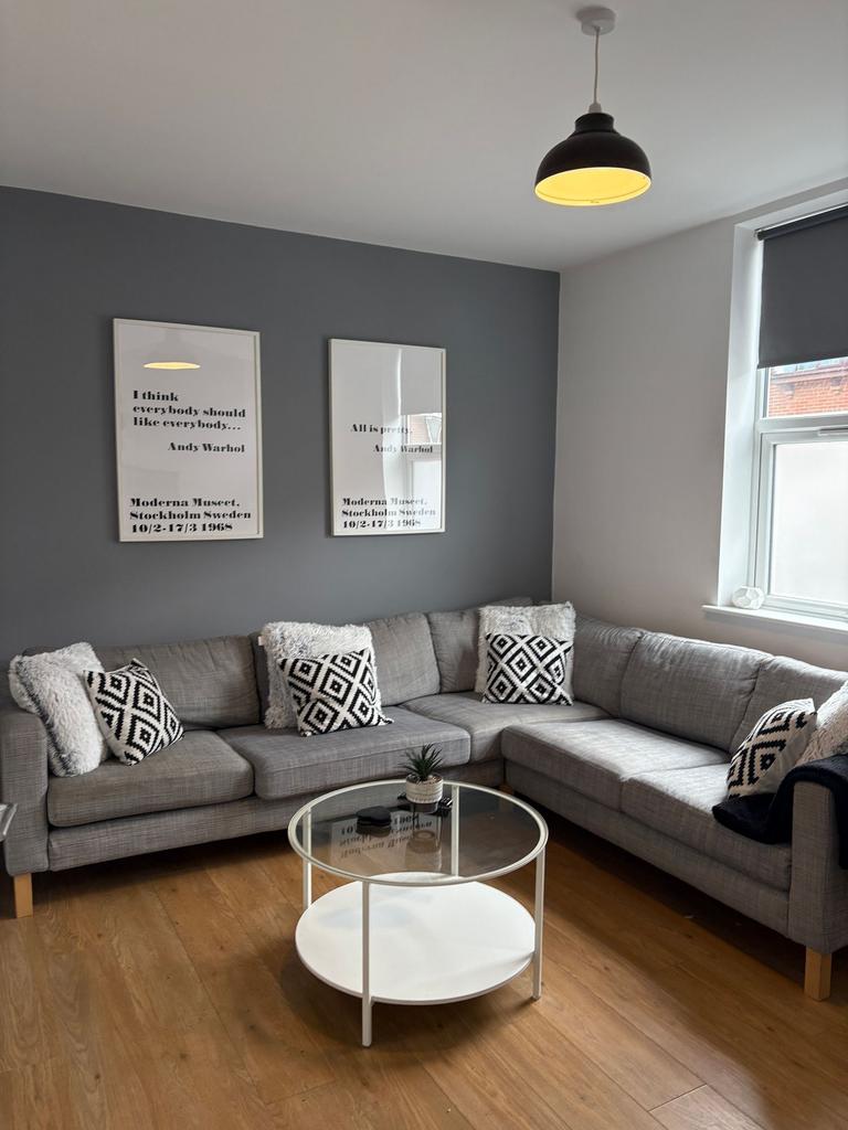 Bright, modern living room with an L-shaped gre...