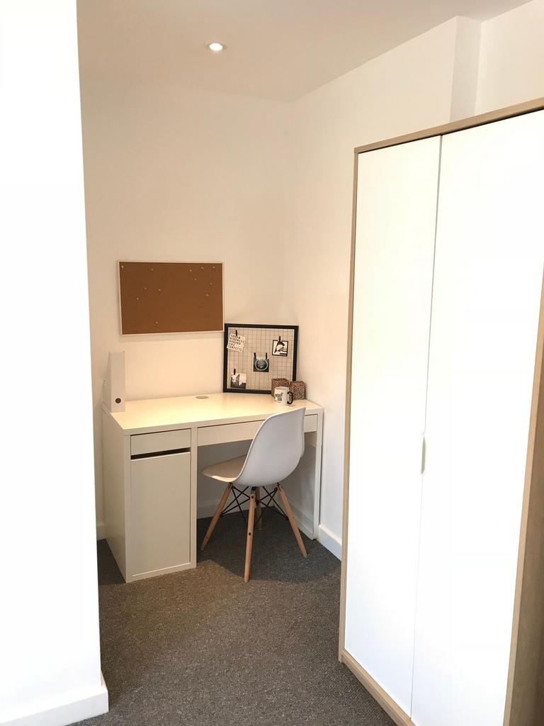 Bright, minimalist single bedroom corner with a...