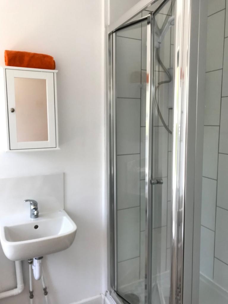 Bright, modern bathroom with a tiled shower enc...