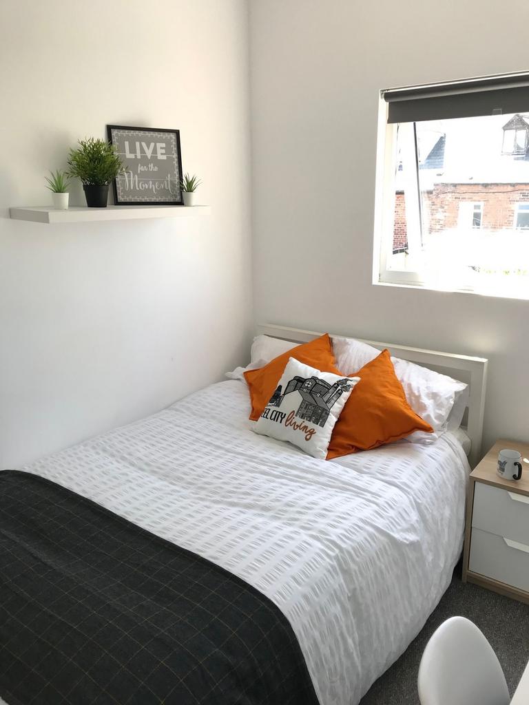 Bright, neatly presented bedroom with a comfort...