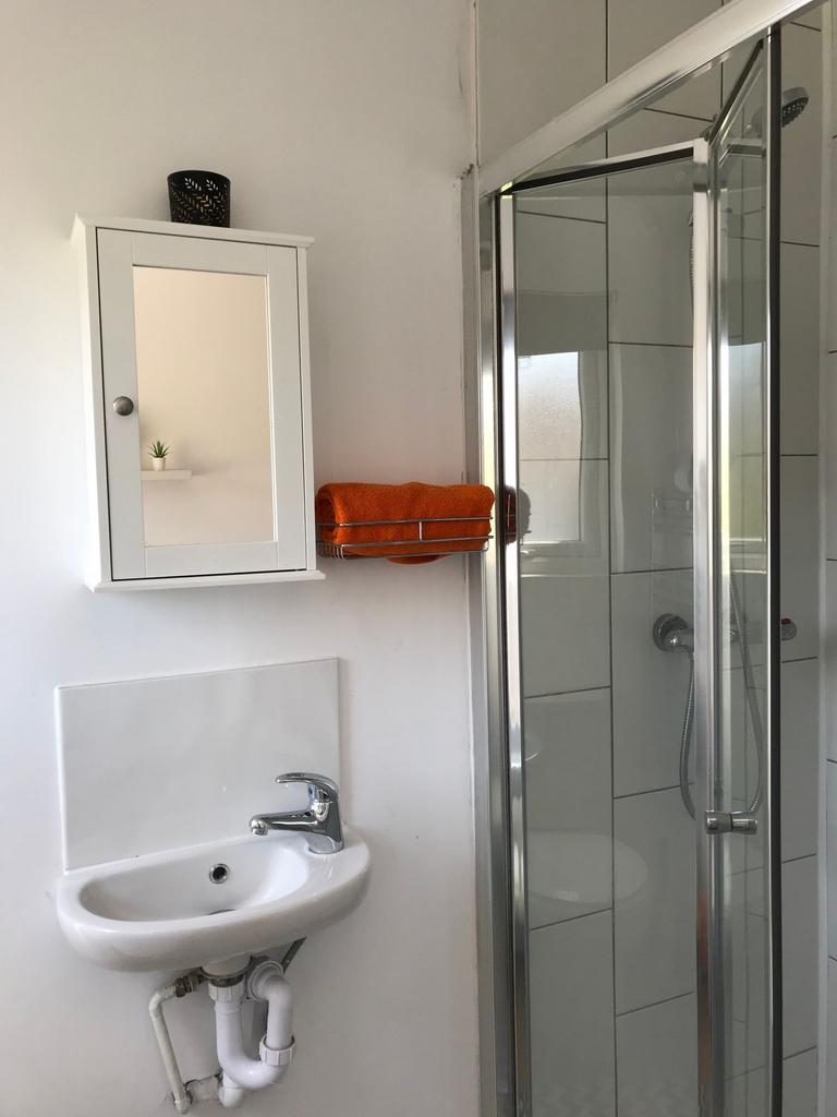 Bright, modern bathroom with a corner shower an...