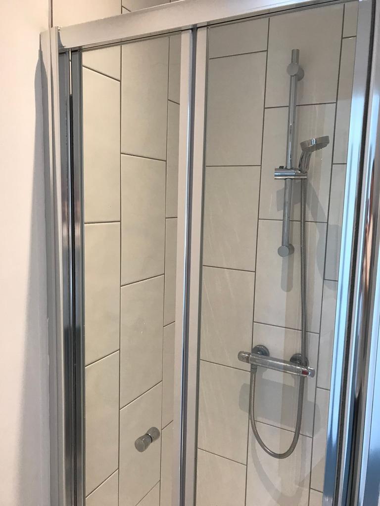 Modern tiled shower enclosure with chrome fitti...