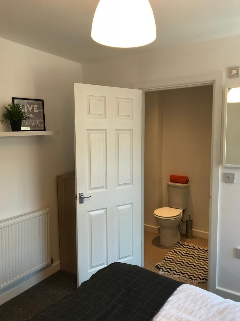 Bright, simply styled bedroom with neutral wall...
