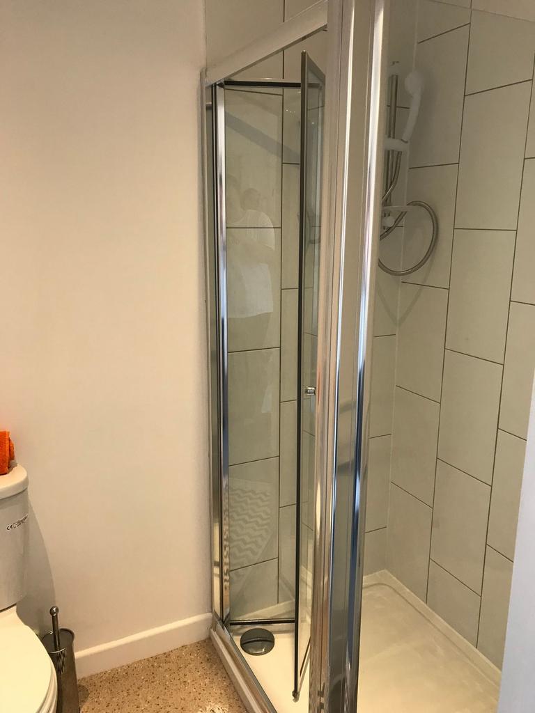 Tidy modern bathroom with a corner glass shower...