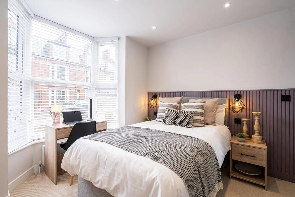 Bright, neatly styled double bedroom with a com...