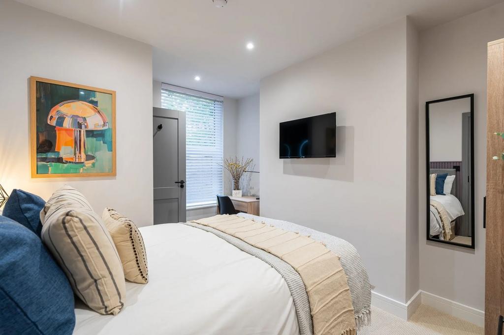Bright, modern double bedroom with a comfortabl...