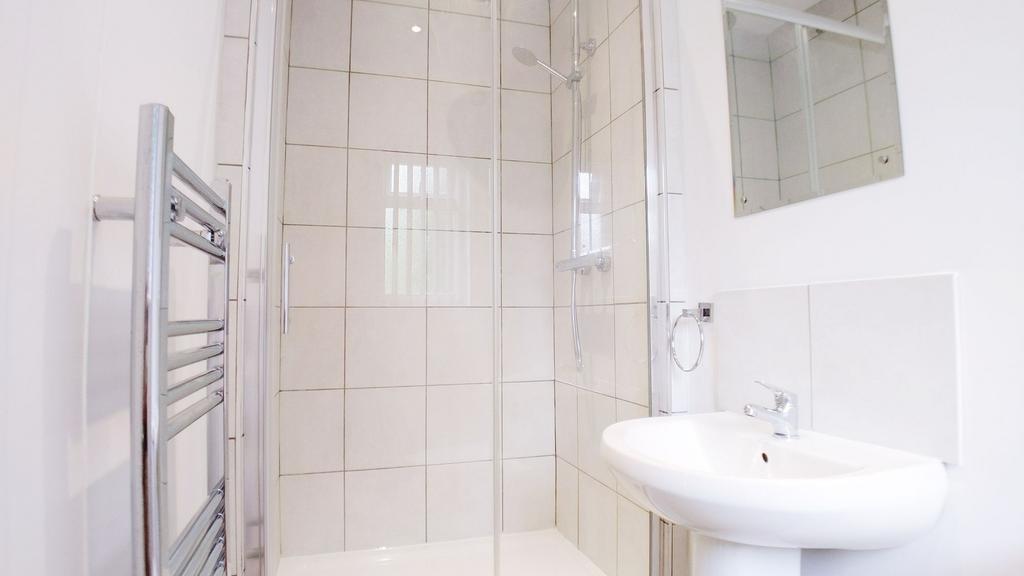 Bright modern bathroom with large tiled walk-in...