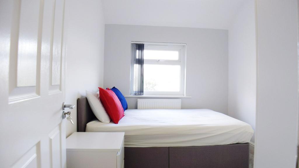 Bright, neutrally decorated bedroom with a comf...