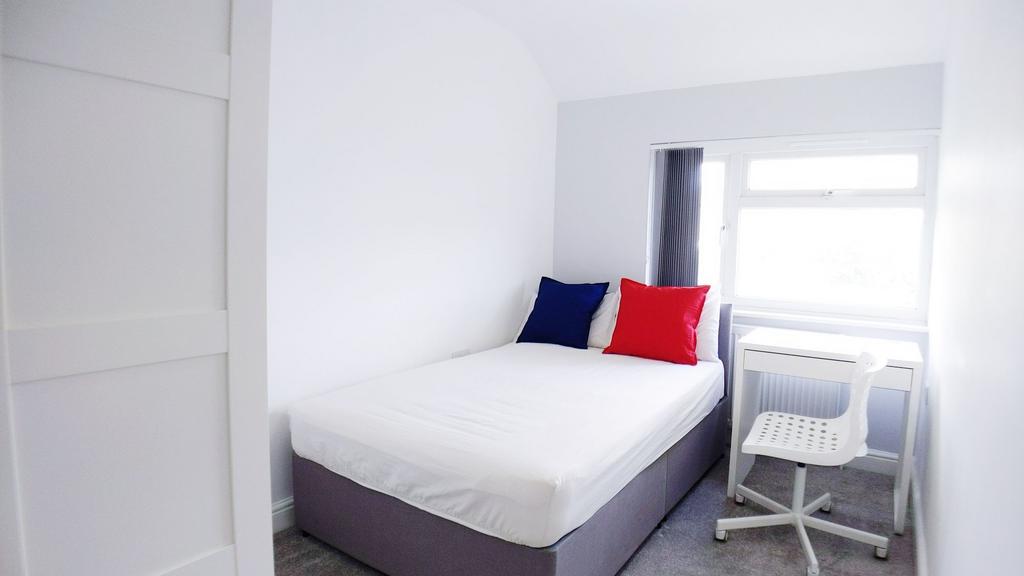 Bright, freshly painted bedroom with a comforta...