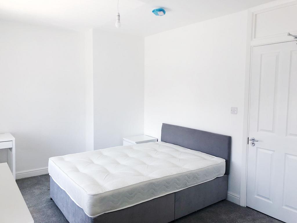 Bright, freshly painted double bedroom with a c...