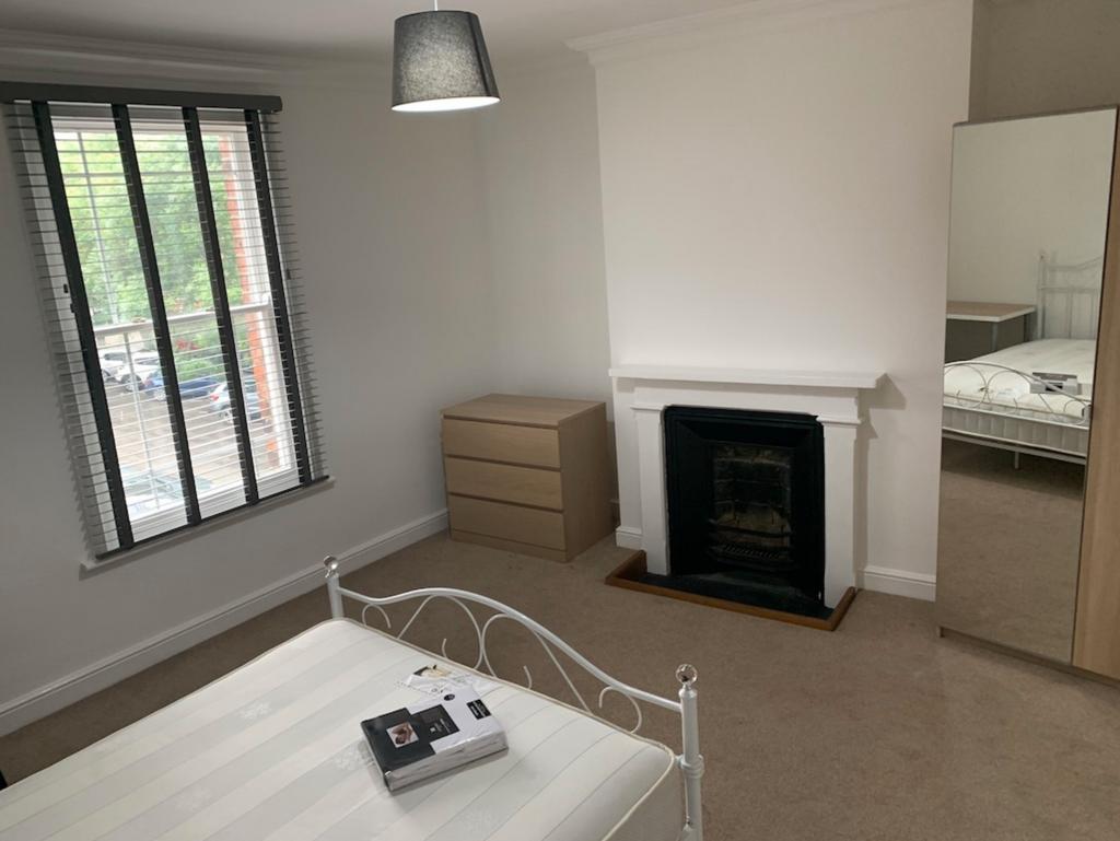Bright, neatly presented bedroom with a decorat...