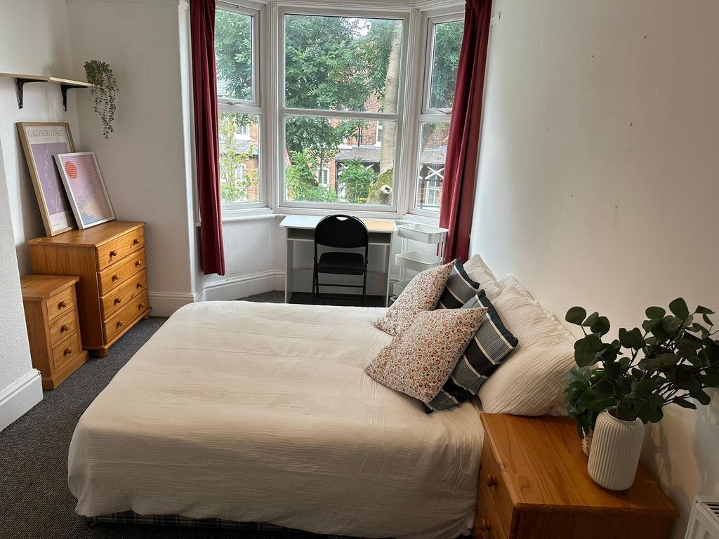 A cozy double bedroom featuring a comfortable b...