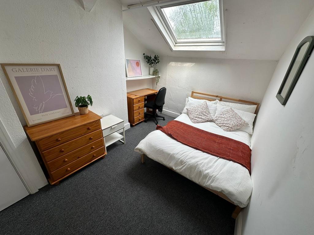 A bright and cozy bedroom featuring a double be...