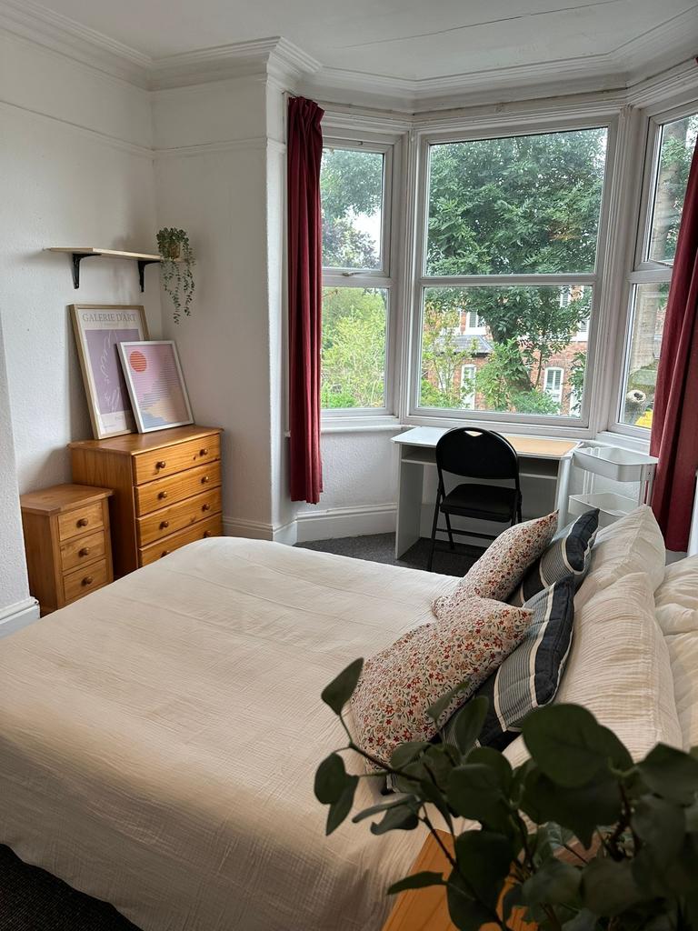 Bright and inviting bedroom with large windows ...