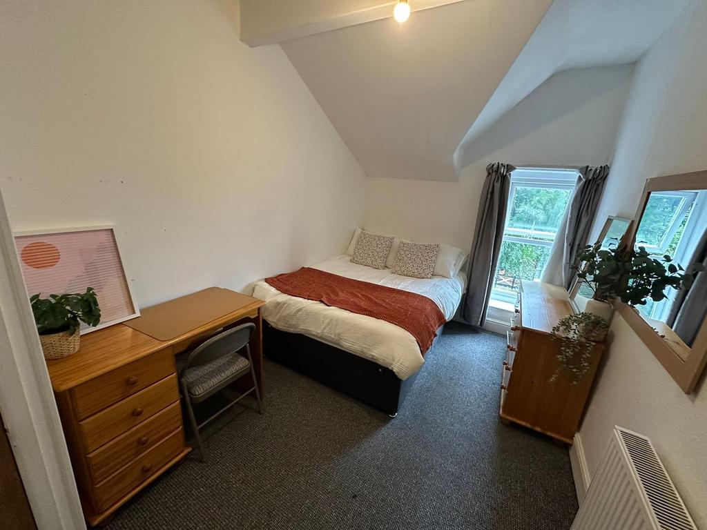 A cozy and well-lit double bedroom featuring a ...